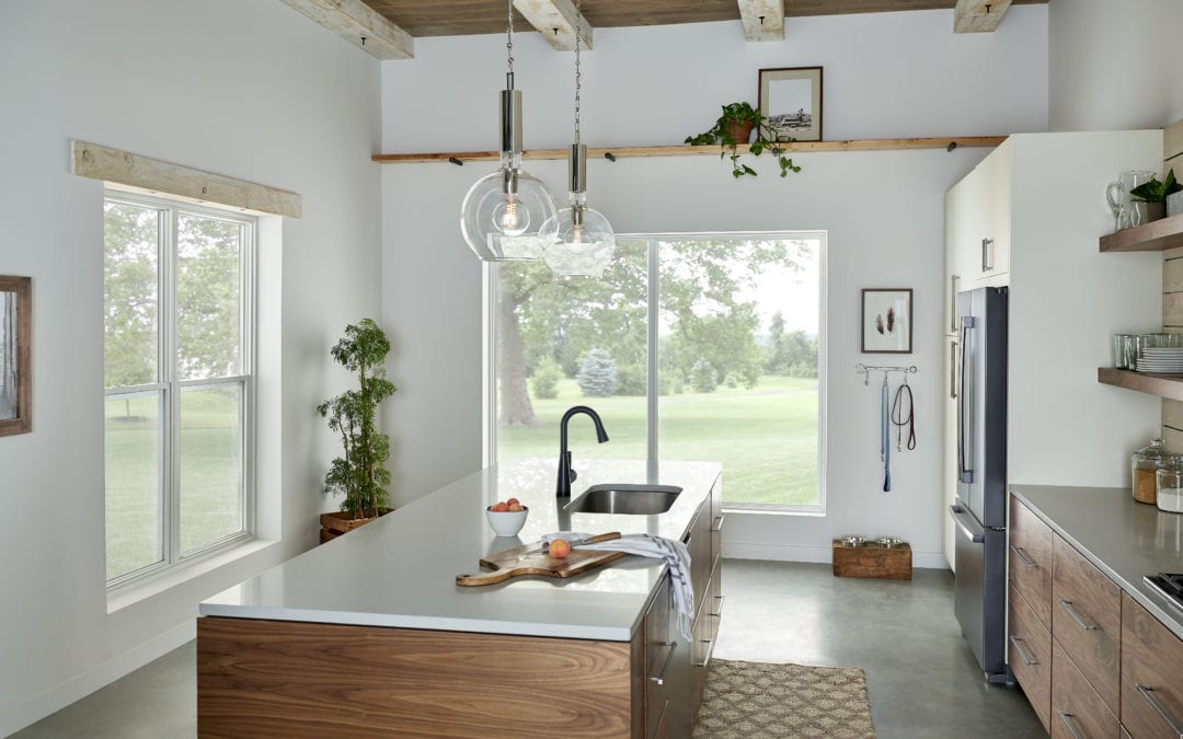 A well-lit kitchen with white walls, wooden cabinets and concrete floors